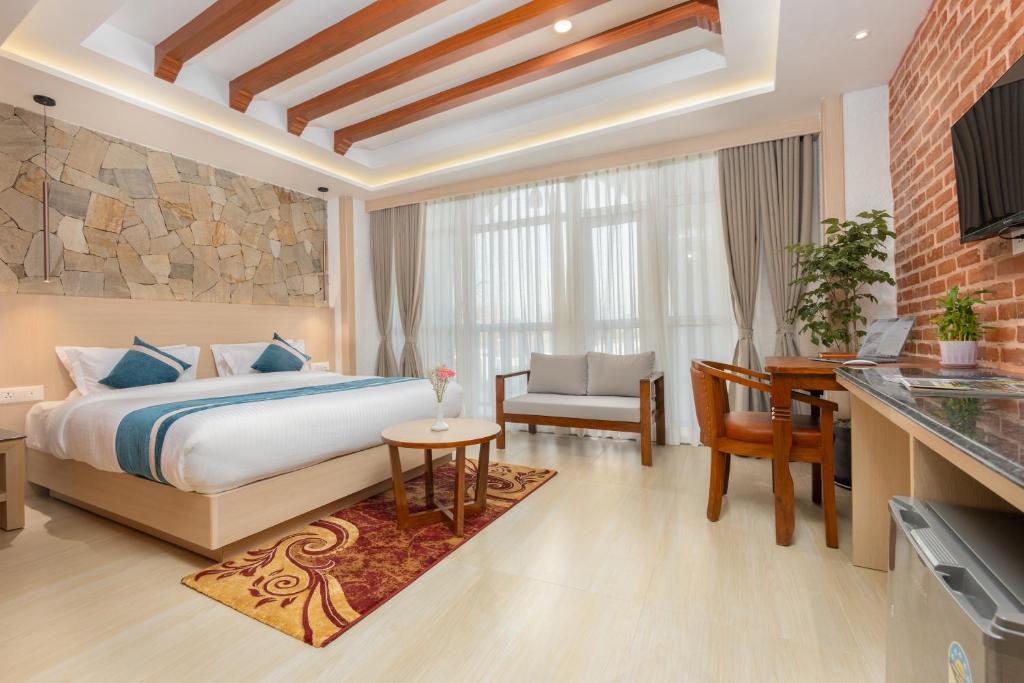 a hotel room with a bed and a table and a desk at Tulsi Kathmandu Hotel in Kathmandu