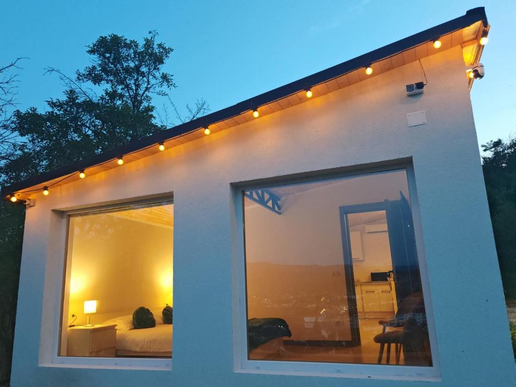 een wit huis met lichten erop bij Epic Glamping in Călimăneşti