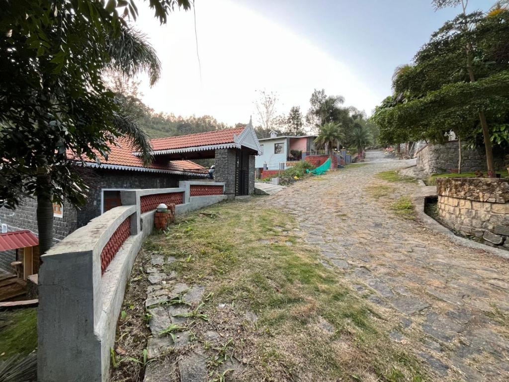 a dirt road next to a house and a building at Honeycomb Abode in Salem