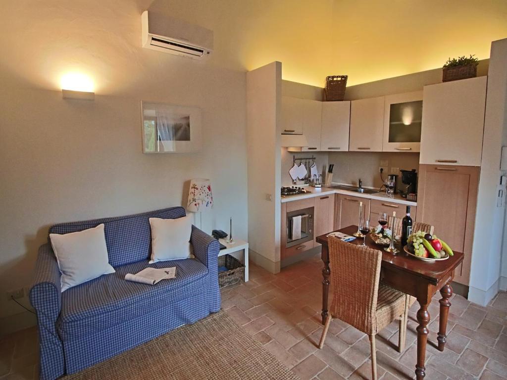 een woonkamer met een bank en een tafel en een keuken bij Modern holiday home in Foligno - Loc with pool in Case Vecchie