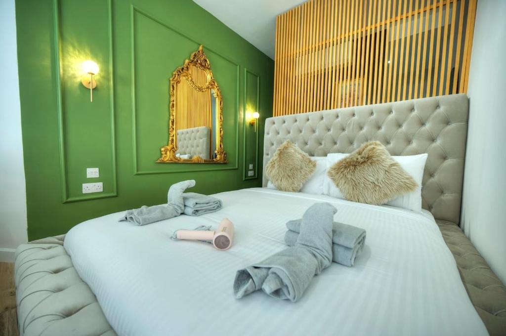 ein Schlafzimmer mit einem großen weißen Bett mit grünen Wänden in der Unterkunft The Loft in Sliema