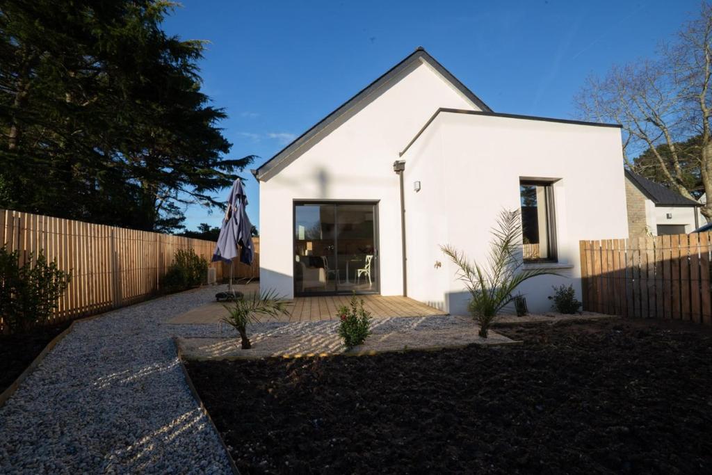 een wit huis met een hek ervoor bij Kercabellec in Mesquer