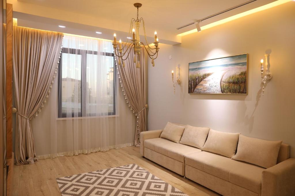 een woonkamer met een bank en een kroonluchter bij Lavender H in Khujand