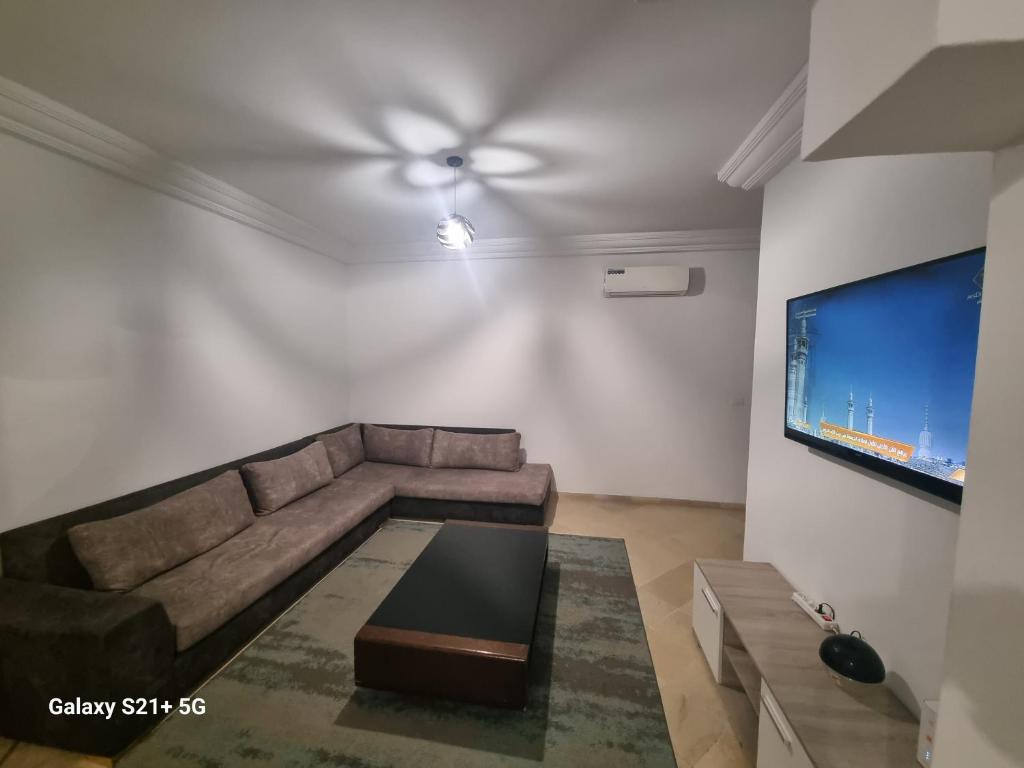 a living room with a couch and a flat screen tv at bienvenu chez moi in Sfax