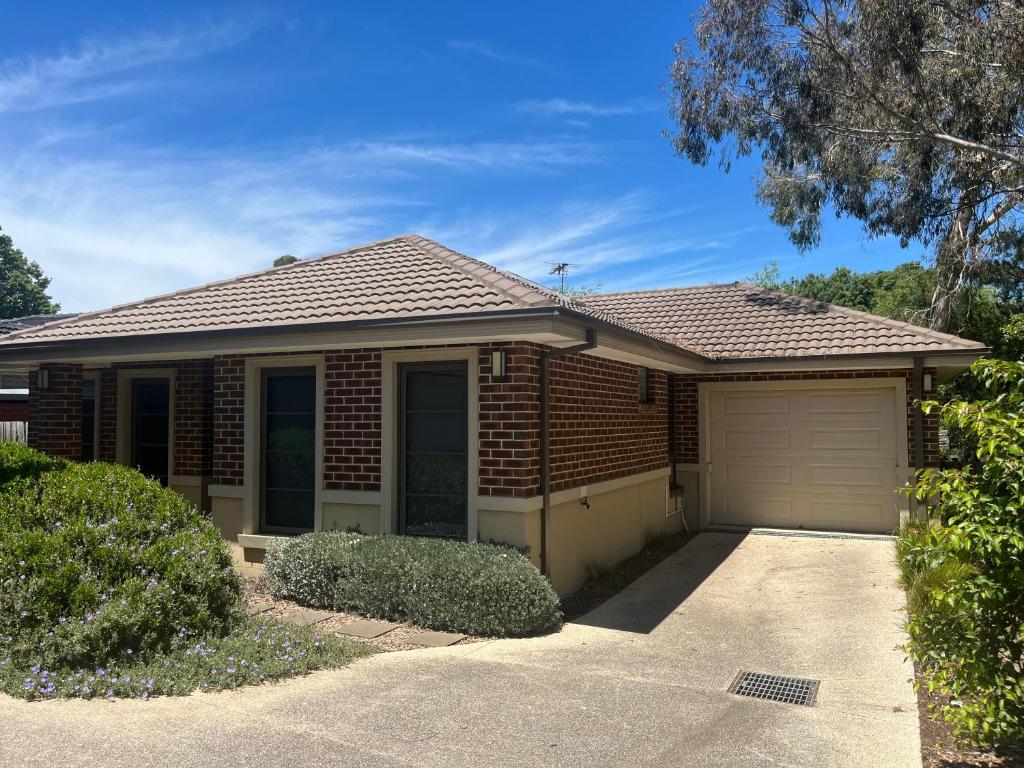 a red brick house with a garage at Your Leafy Ivanhoe Retreat in Melbourne