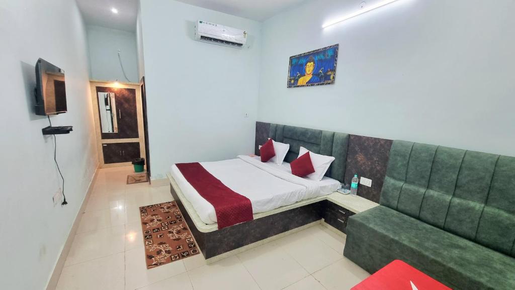 a bedroom with a bed and a green couch at Hotel Vijay Greens in Orchha