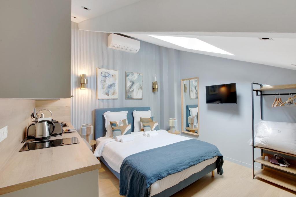 een hotelkamer met een bed en een keuken bij Charmant et central - Neuilly in Neuilly-sur-Seine