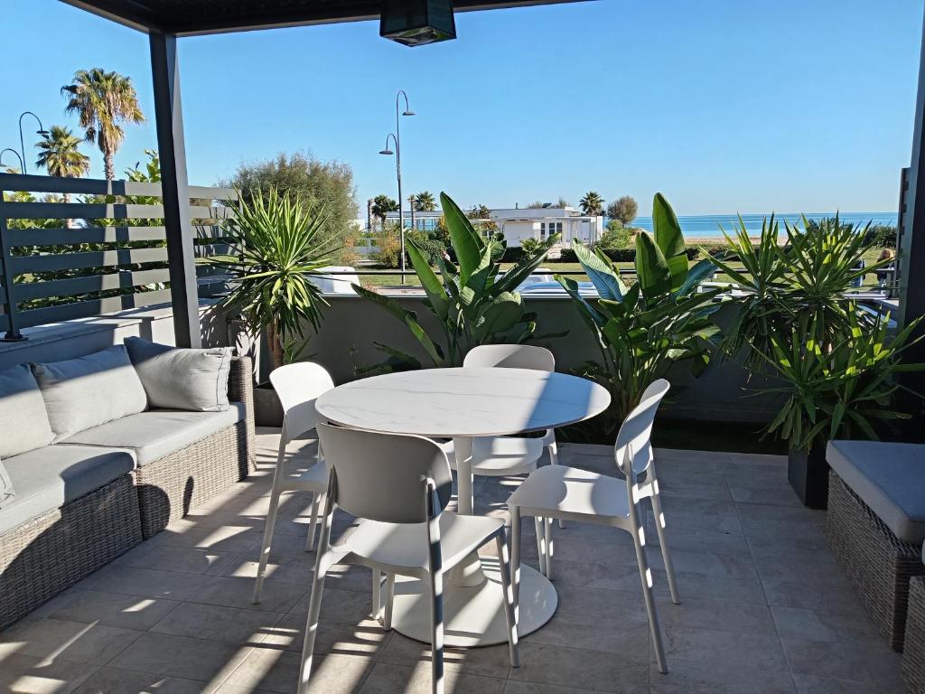 een terras met een tafel en stoelen en de oceaan bij SUITE CONTI 36 terrazza sul mare in Porto SantʼElpidio