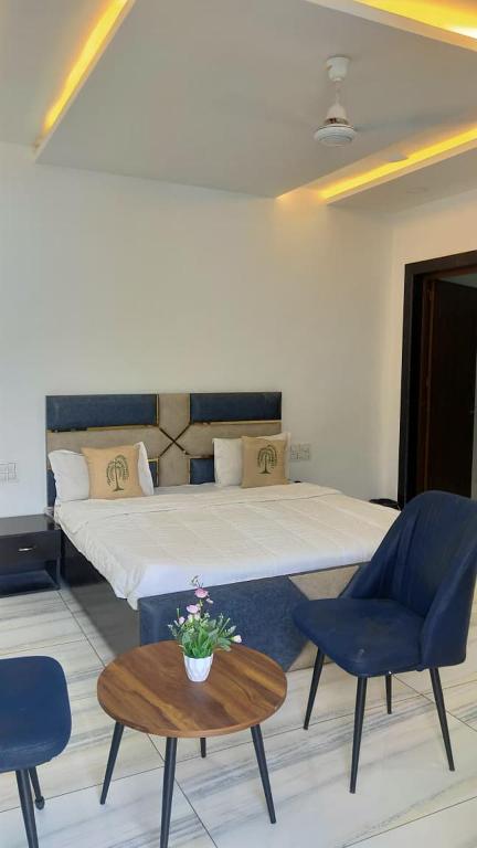 a bedroom with a bed and two chairs and a table at Hill Touch Villa in Thūr