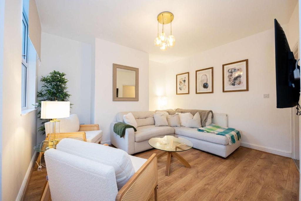 a living room with a couch and a table at Goulder House- Close To Motorway & CO-OP Live in Manchester