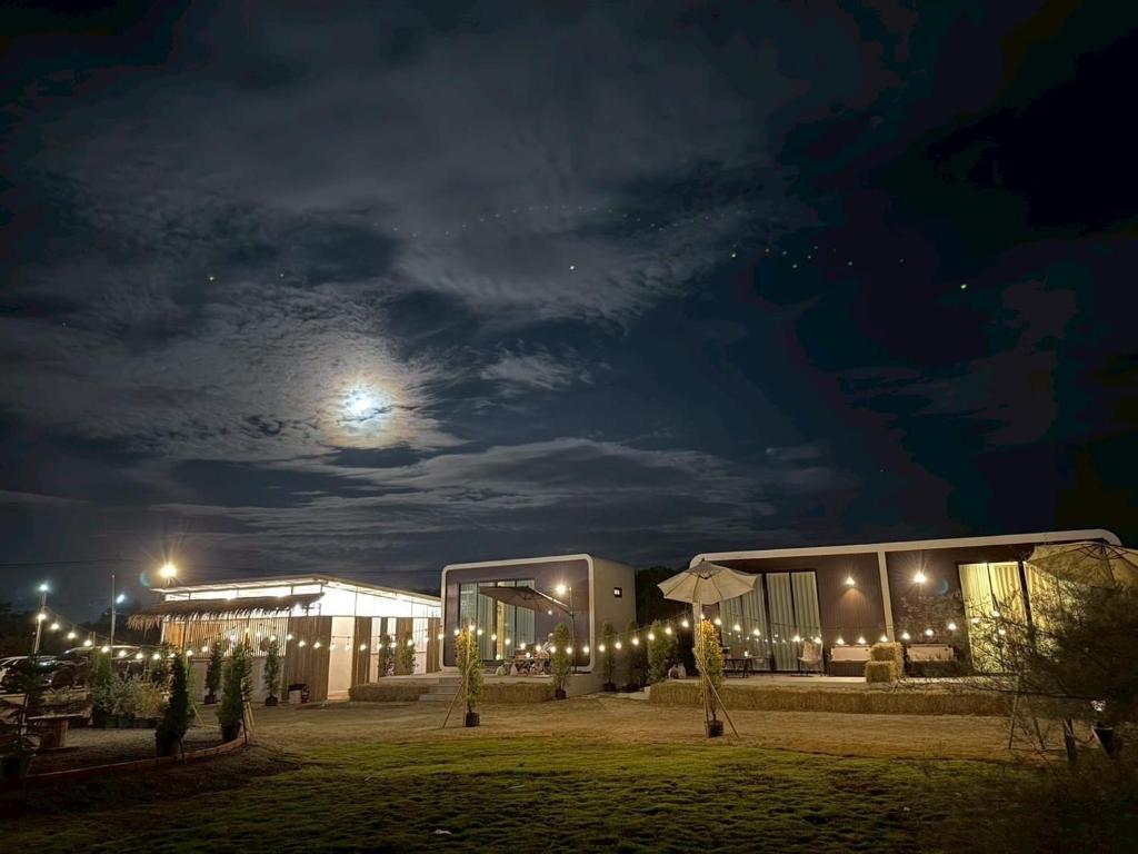 a building at night with the moon in the sky at LeLaNa Farmstay Camping in Pak Chong