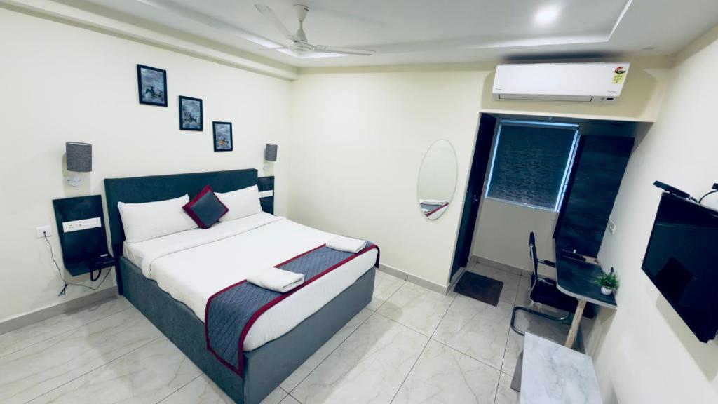 a bedroom with a bed and a tv in it at Seasons Stay in Vijayawāda