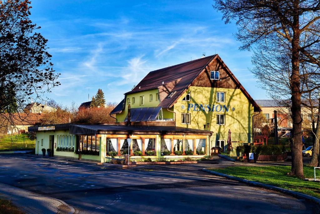 a large yellow building with a gambrel roof at MOTOREST-PENSION U HRACHŮ,s.r.o. in Klatovy