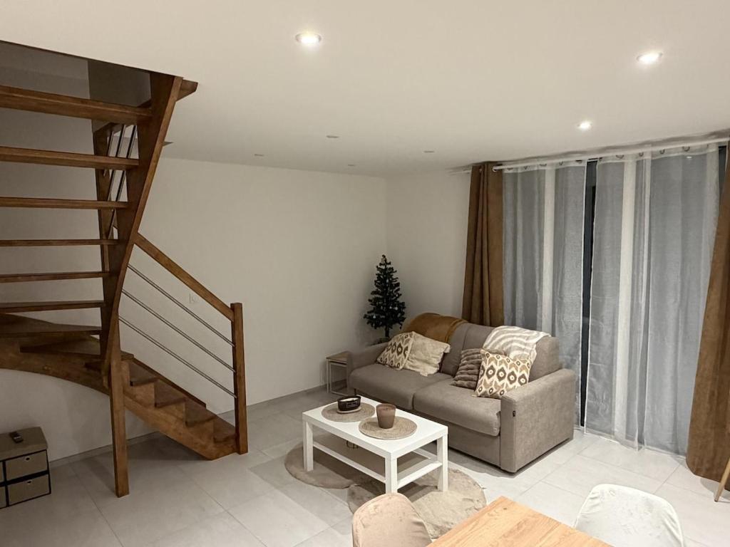 a living room with a couch and a staircase at Ecrin de Lin in Rosnoën