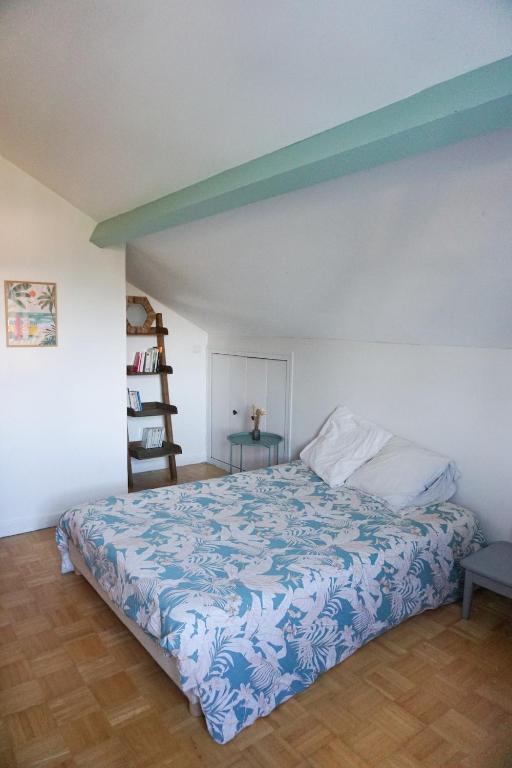 una camera con un letto con copriletto blu e bianco di Appartement confort tout équipé a Montrevel-en-Bresse