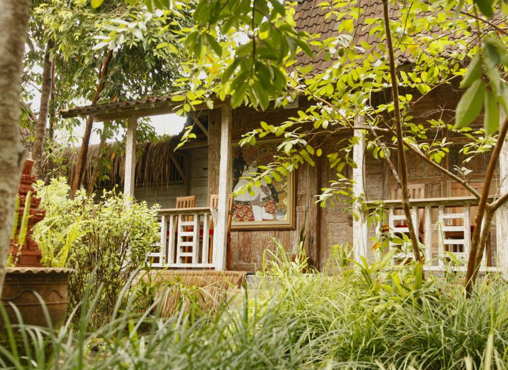 an old house in the middle of a garden at Ardan Maison The Garden Villas in Ubud