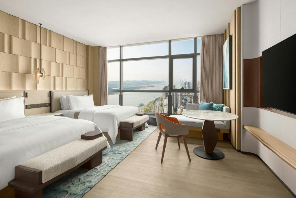 a hotel room with two beds and a table at The Westin Yichang in Yichang