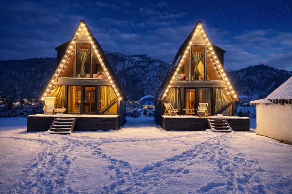 a log cabin in the snow with lights at Borjomi Hills in Borjomi