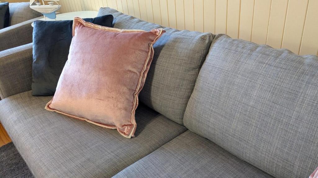 a couch with two pillows sitting on it at Bonnie Brae Retreat in Swansea