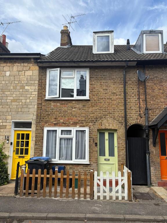 a brick house with colorful doors and a fence at The Windsor Room in Windsor