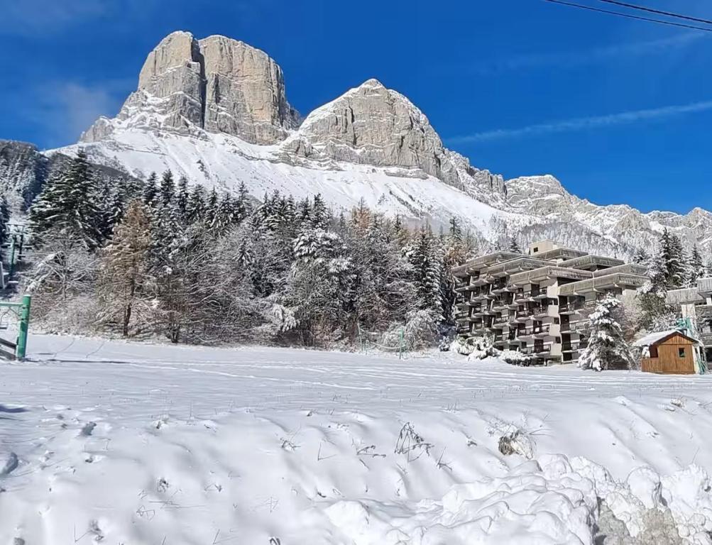 a snow covered mountain in front of a lodge at Col de L'Arzelier in Château-Bernard