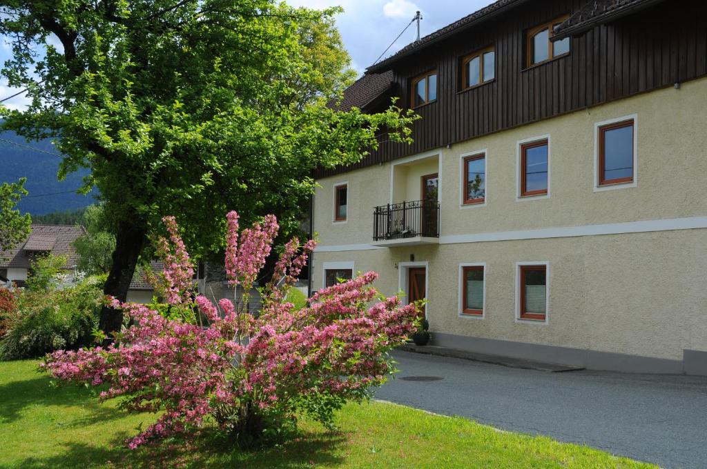 a building with pink flowers in front of a building at Gästehaus Brugger in Hermagor