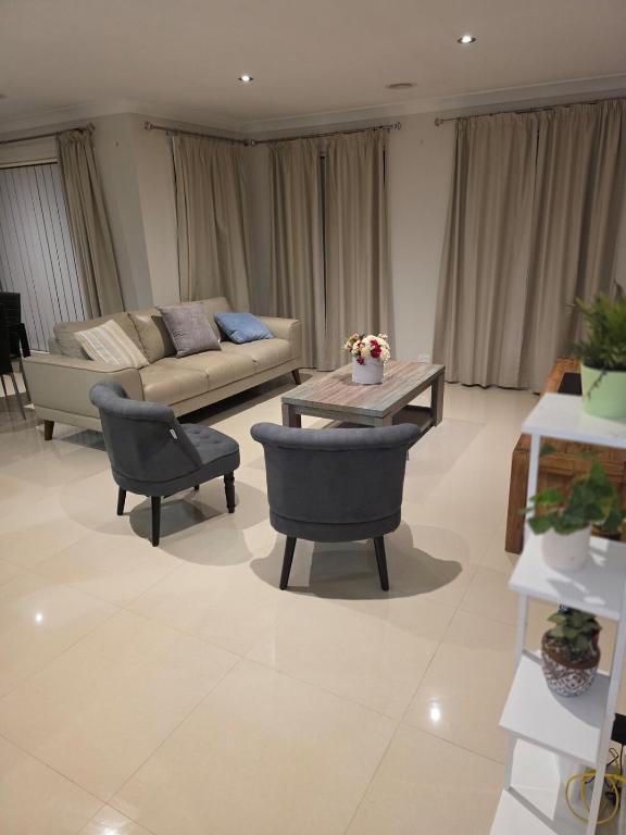 a living room with a couch and a table and chairs at Four-bedroom house in Gungahlin
