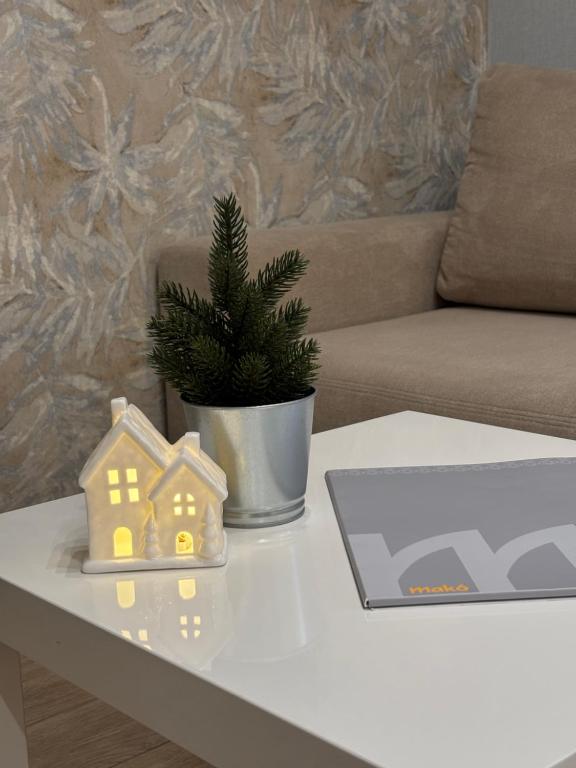 un tavolo con un computer portatile e una casa giocattolo sopra di Premium Apartman a Makó