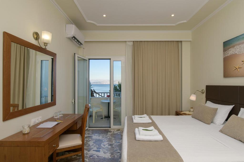 een hotelkamer met een bed, een tafel en een bureau bij Hotel Kaiser Bridge in Benitses