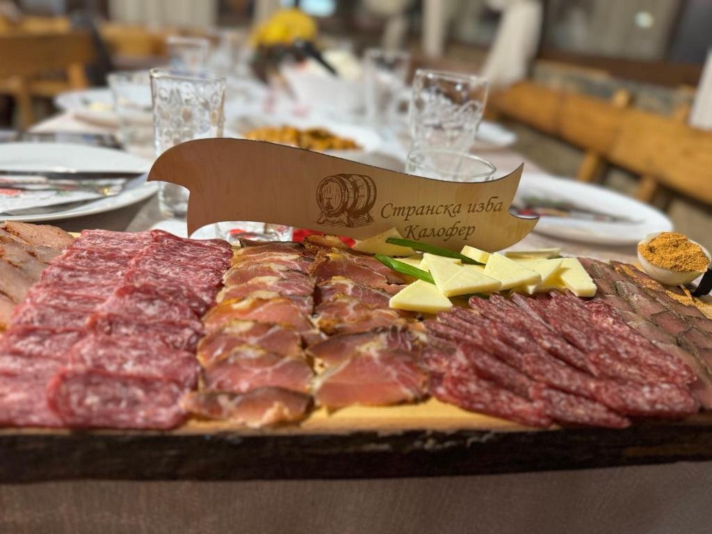 un vassoio di carne e formaggio su un tavolo di Странската изба a Kalofer