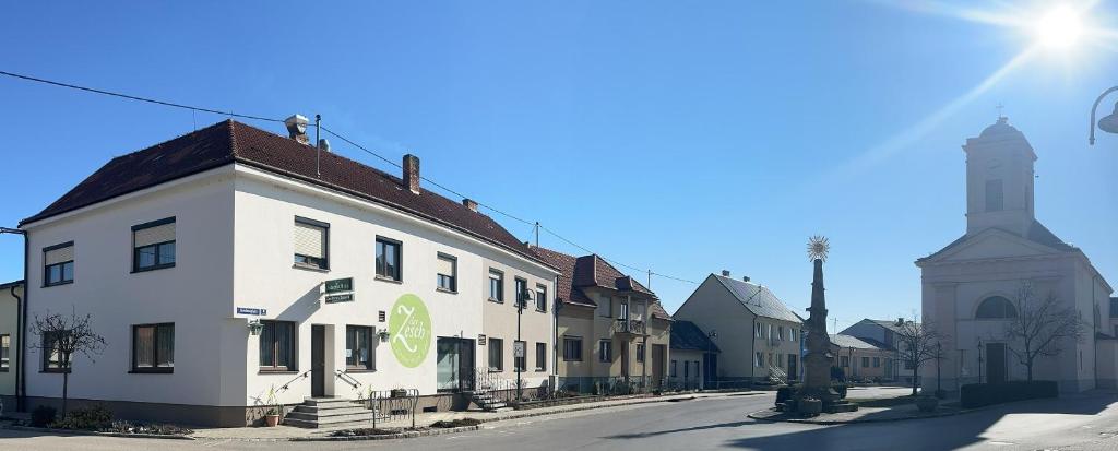 een wit gebouw met een klokkentoren op een straat bij Der Zesch in Schrattenberg
