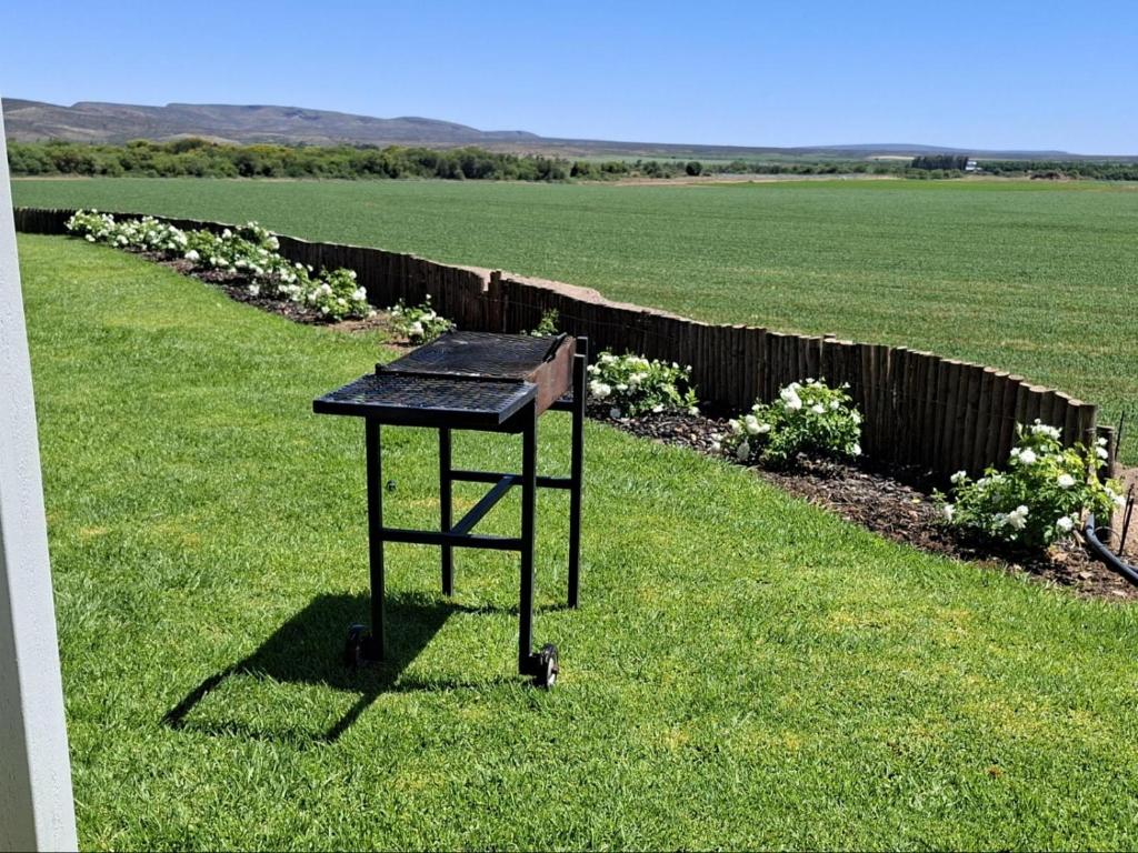 a black table sitting in the grass in a field at Leopolds Rest in Prieska