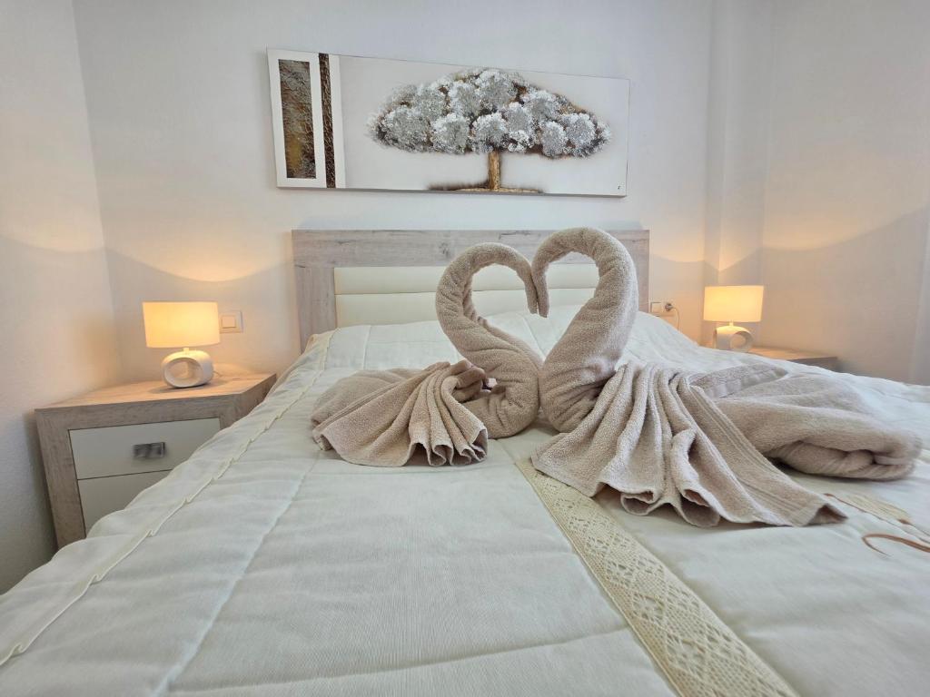 two swans are sitting on top of a bed at La Casa de Torrevieja in Torrevieja