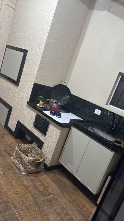 a kitchen with a black counter top and a table at Casa praia in Capão da Canoa