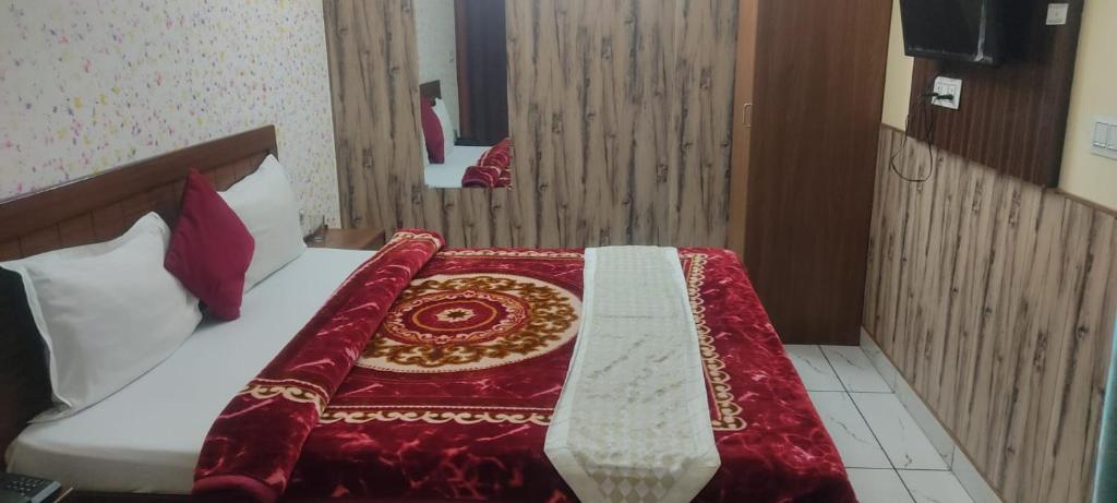 a bedroom with a bed with a red blanket on it at Hotel Neel Kamal Near Chandigarh Railway Station in Chandīgarh