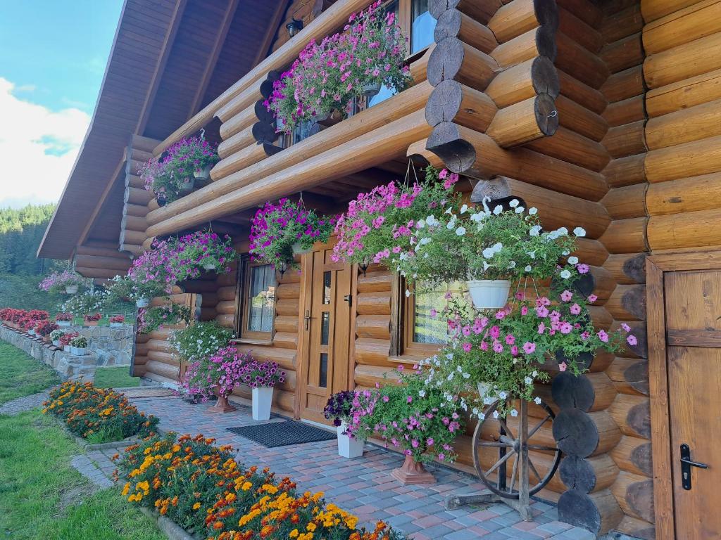 a house with flowers on the side of it at Stream House in Lopushnoye