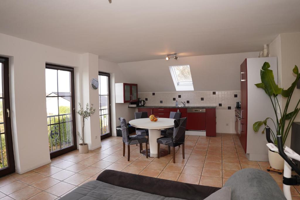 een woonkamer met een tafel en een keuken bij Panoramablick, ruhiger Lage, 20 Min nach Köln - EVARIS Hilda in Overath