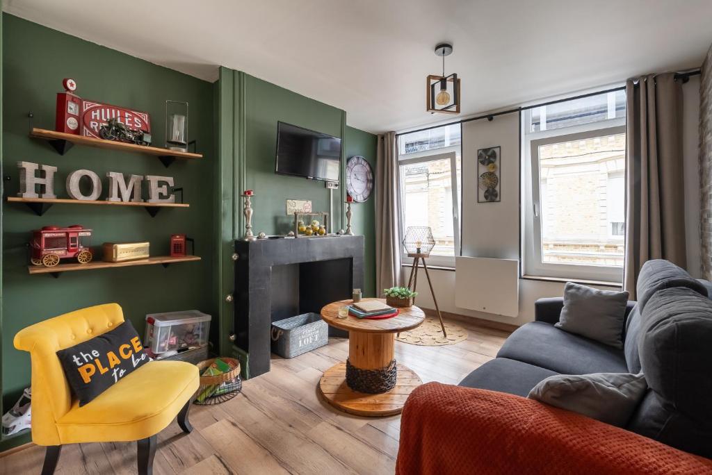 a living room with a couch and a fireplace at comme un air de chez soi in Calais
