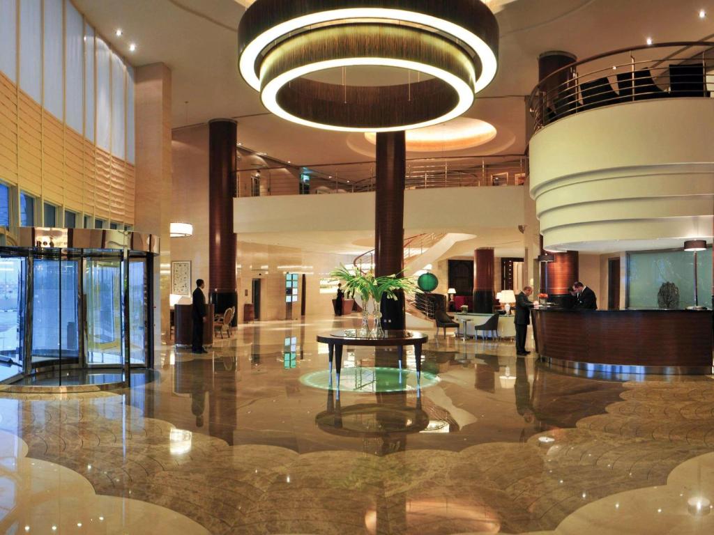 una hall con tavolo e grande lampadario a braccio di Mövenpick Hotel Al Khobar a Al Khobar