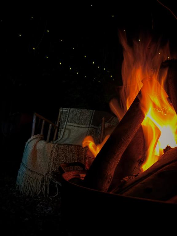 a fire in a fire pit at night at Casa De Piedra Le Petit Chalet in San Clemente
