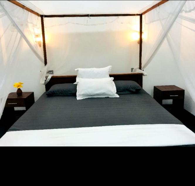 a bedroom with a large bed with two pillows at silent beach House For Ever in Tangalle