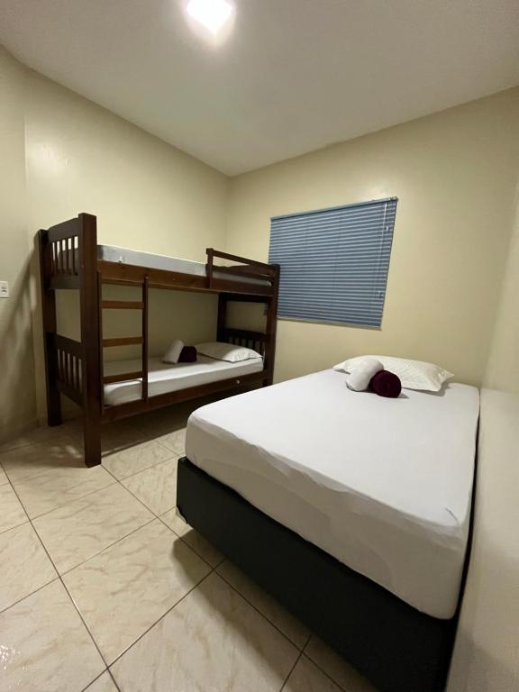 una camera con due letti e un letto a castello di Casa com piscina bem localizada a Anápolis