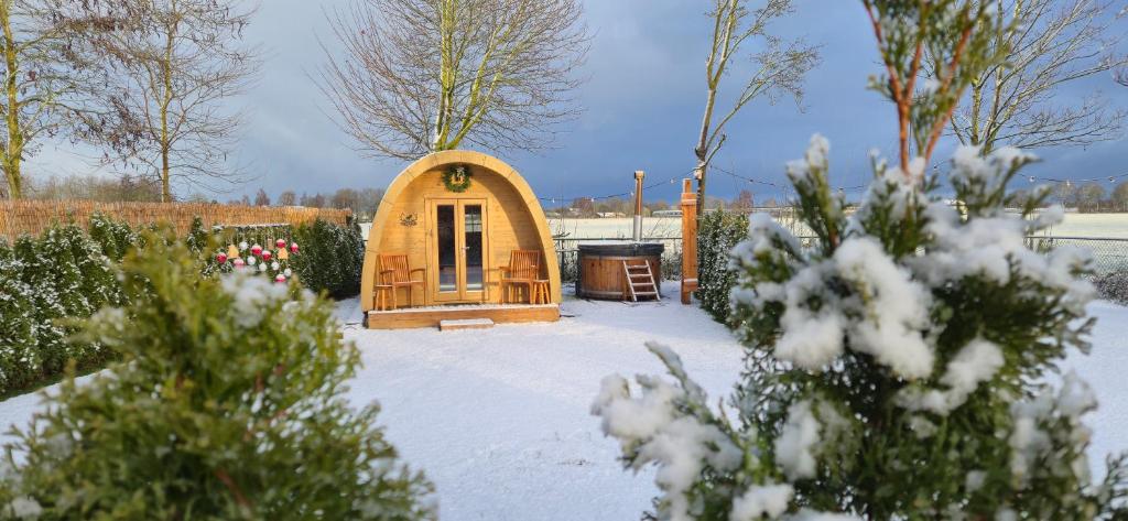 a small tree house in a yard in the snow at Cosy Cabin Overloon in Overloon