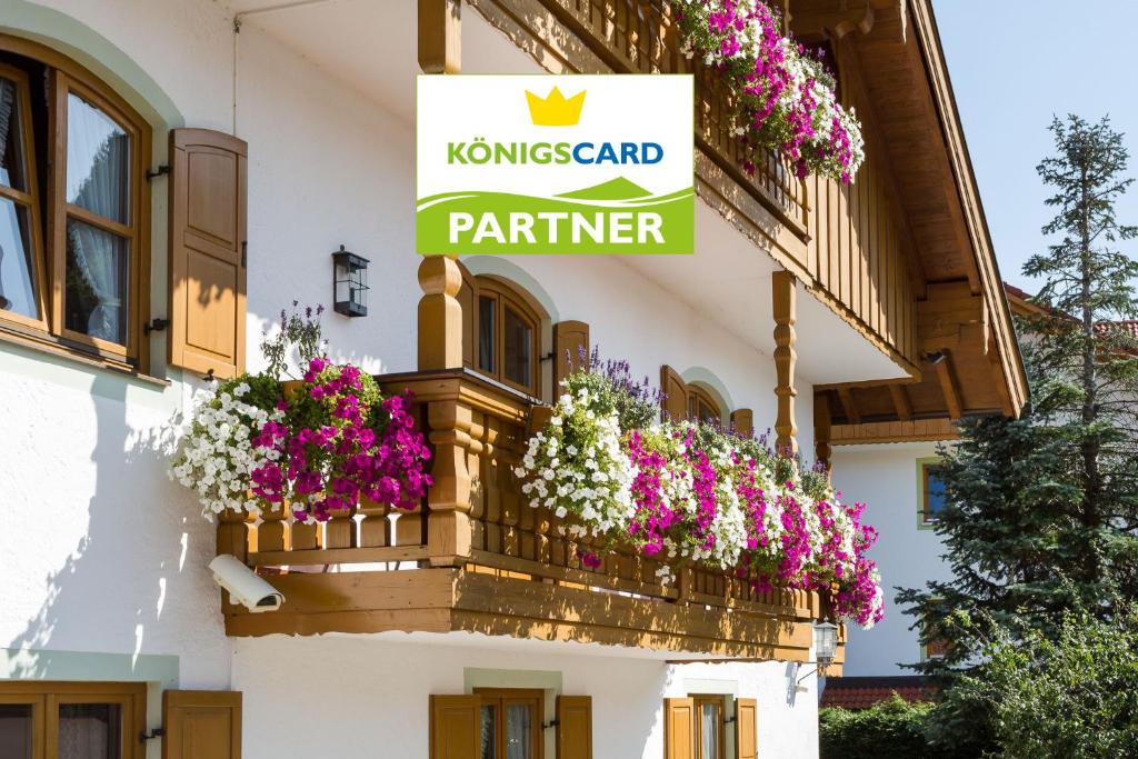 een bord op een gebouw met bloemen op een balkon bij Landhaus Hubertus in Bad Tölz