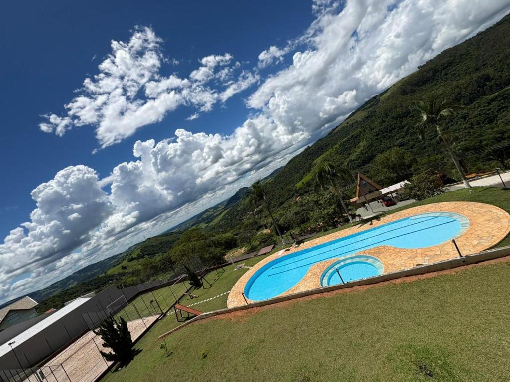 a large swimming pool on top of a grass field at Apartamento Inteiro Próximo ao Centro in Águas de Lindoia
