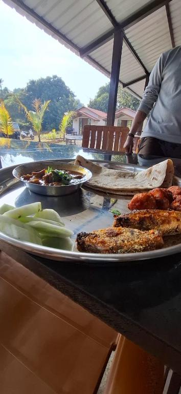 a table with several plates of food on it at Amrutvel Resort in Pune