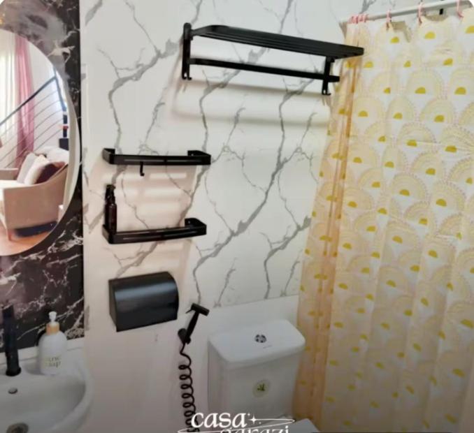 ein Bad mit WC und ein Telefon an der Wand in der Unterkunft Casa Garazi in Calo