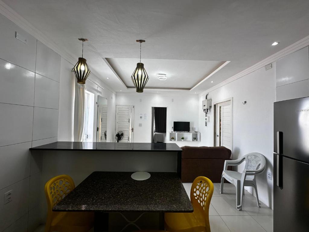 a kitchen and living room with a table and chairs at AP Brisa do Rio in Galinhos