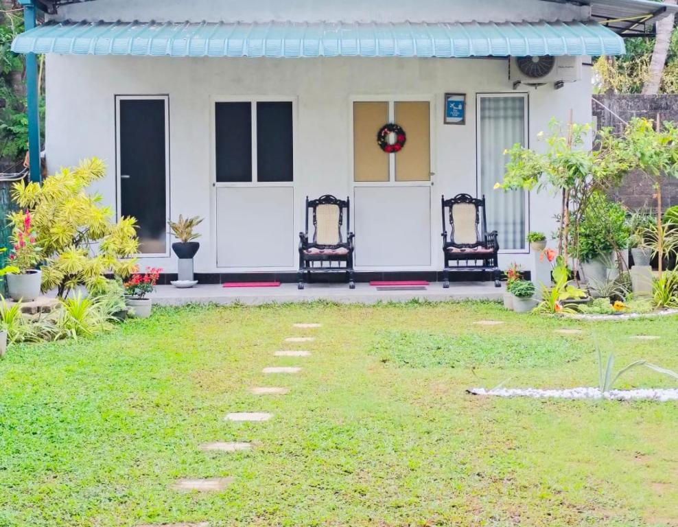een huis met twee stoelen en een tuin bij TN Travel Inn - Katunayake in Katunayaka