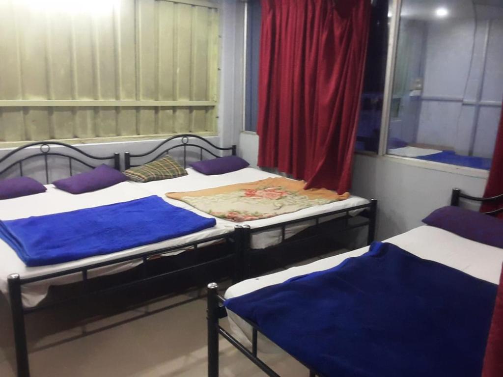 un gruppo di tre letti in una stanza di SGH Mysore dorm bus rail station a Mysore